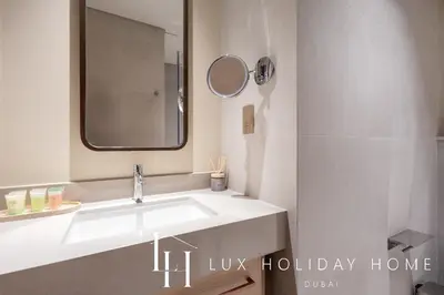a bathroom with a white sink and a mirror at LUX The Vida Burj Khalifa View Suite in Dubai