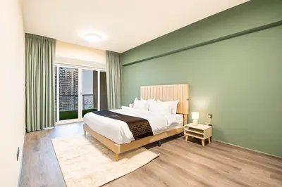 a bedroom with a large bed and a large window at Escape24 Luxury 2BR with Large Balcony and Lake Views in Dubai