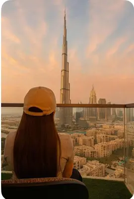 a woman looking out of a window at a city at Burj Khalifa View 1BHK 5 people Downtown Dubai in Dubai