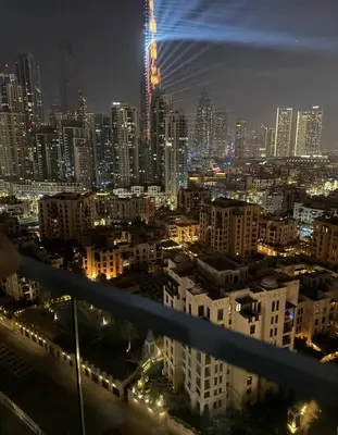 a view of a city at night with lights at Burj Khalifa View 1BHK 5 people Downtown Dubai in Dubai