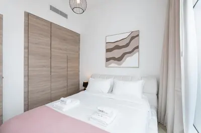 a bedroom with a white bed with two towels on it at Chic 2BHK Retreat with Marina Views by Czechin in Dubai