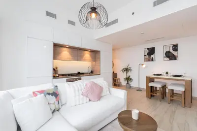 a living room with a white couch and a table at Chic 2BHK Retreat with Marina Views by Czechin in Dubai