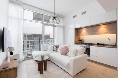 a living room with a white couch and a kitchen at Chic 2BHK Retreat with Marina Views by Czechin in Dubai