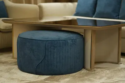 a coffee table with a blue ottoman under a table at The Royale Blue Suite 610 I JVC I Plunge Pool Parking Gym in Dubai