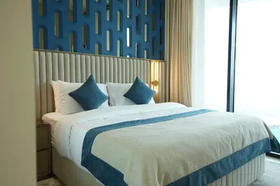 a bedroom with a large bed with blue and white sheets at The Royale Blue Suite 610 I JVC I Plunge Pool Parking Gym in Dubai