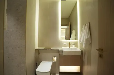 a bathroom with a toilet and a sink and a mirror at The Royale Blue Suite 610 I JVC I Plunge Pool Parking Gym in Dubai