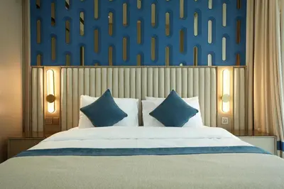 a bedroom with a large bed with blue and white pillows at The Royale Blue Suite 610 I JVC I Plunge Pool Parking Gym in Dubai