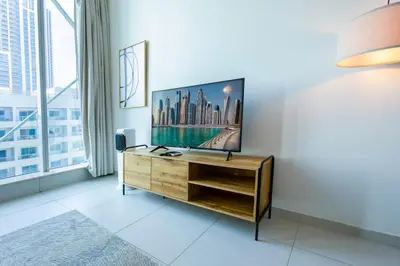 a room with a desk with a tv on a wall at 1BHK at Panoramic Tower, Marina with Sea and Canal View in Dubai