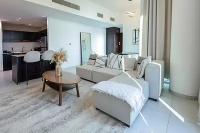 a living room with a white couch and a table at 1BHK at Panoramic Tower, Marina with Sea and Canal View in Dubai