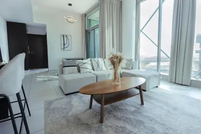 a living room with a couch and a table at 1BHK at Panoramic Tower, Marina with Sea and Canal View in Dubai