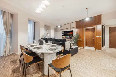a dining room and living room with a table and chairs at Modern 4BR Suite Overlooking Downtown in Dubai