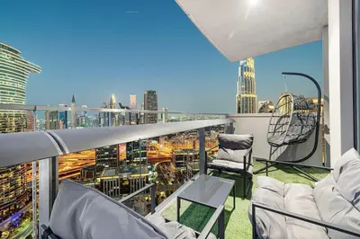 a balcony with chairs and a view of a city at Modern 4BR Suite Overlooking Downtown in Dubai