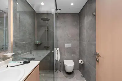 a bathroom with a shower and a toilet and a sink at Samaya Holiday Homes - Cloud Stylish Suites with Balcony in Dubai