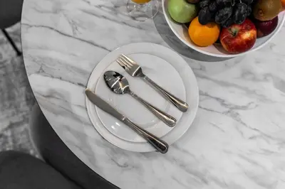 a table with plates of fruit and silverware on it at Samaya Holiday Homes - Cloud Stylish Suites with Balcony in Dubai