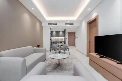 a living room with a couch and a tv at Samaya Holiday Homes - Cloud Stylish Suites with Balcony in Dubai