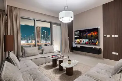 a living room with a couch and a flat screen tv at Luxury 4BR Burj Khalifa View Dubai Mall in Dubai