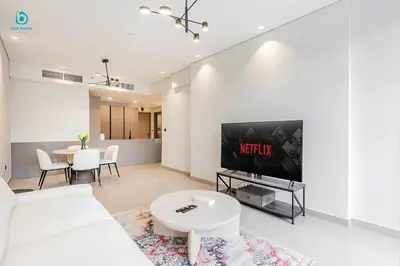 a living room with a white couch and a tv at Blue Breeze Cozy 1 BR in JVC Al Serh Residence 11 in Dubai