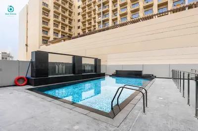 a swimming pool in the middle of a building at Blue Breeze Cozy 1 BR in JVC Al Serh Residence 11 in Dubai