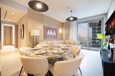 a dining room with a table and chairs and a couch at 2BR Luxury Hotel Amenities Dubai Mall Access in Dubai