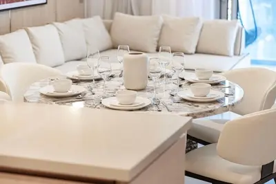 a table with glasses and plates and a couch at 2BR Luxury Hotel Amenities Dubai Mall Access in Dubai