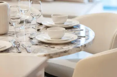 a table with plates and wine glasses on it at 2BR Luxury Hotel Amenities Dubai Mall Access in Dubai