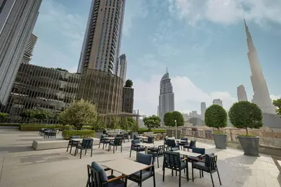 a patio with tables and chairs in a city at 2BR Luxury Hotel Amenities Dubai Mall Access in Dubai