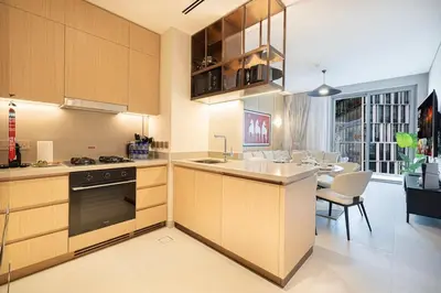 a kitchen with wooden cabinets and a dining room at 2BR Luxury Hotel Amenities Dubai Mall Access in Dubai