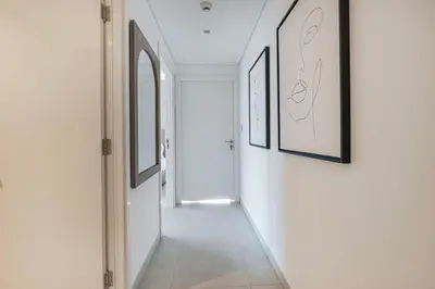 a hallway with white walls and pictures on the walls at 4Bedroom Luxury Stay in Downtown Views Dubai Mall in Dubai