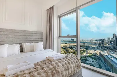 a white bedroom with a large window with a city view at 4Bedroom Luxury Stay in Downtown Views Dubai Mall in Dubai