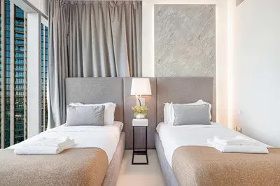 two beds in a hotel room with windows at 4Bedroom Luxury Stay in Downtown Views Dubai Mall in Dubai
