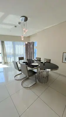 a dining room with a black table and chairs at Burj Khalifa View High Floor and Brand New in Dubai