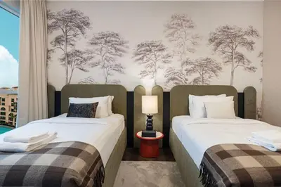 two beds sitting next to each other in a bedroom at Panoramic 4BR Burj Khalifa & Fountain View in Dubai