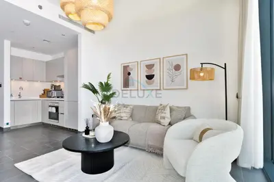 a living room with a couch and a table at Located Few Minutes Drive to Downtown Dubai, Burj Khalifa and Dubai Mall, Surrounded by Lush Green Community - Sobha Hartland The Crest Tower C by Deluxe Holiday Homes in Dubai