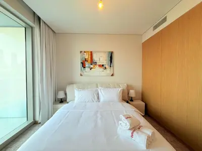 a bedroom with a large white bed and a window at Center to Burj Khalifa I Brand New I High End in Dubai