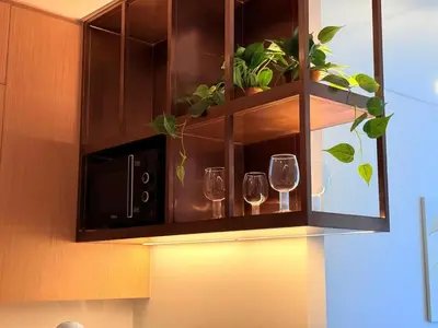 two wine glasses in a cabinet with a microwave at Center to Burj Khalifa I Brand New I High End in Dubai