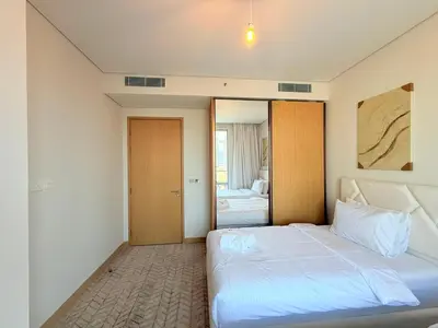 a bedroom with a large white bed and a mirror at Center to Burj Khalifa I Brand New I High End in Dubai