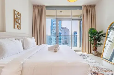 a bedroom with a large white bed and a large window at Stunning Skyline Views and Prime Walkable Location in Dubai