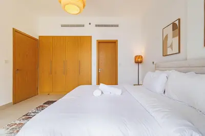 a large white bed with two towels on it at Stunning Skyline Views and Prime Walkable Location in Dubai