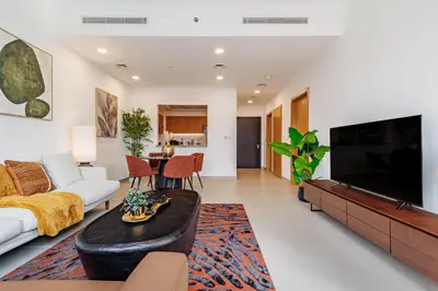 a living room with a couch and a tv at Stunning Skyline Views and Prime Walkable Location in Dubai