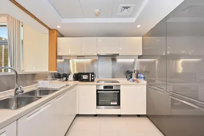 a kitchen with white cabinets and a sink at Luxury 2BR Downtown Walk to Dubai Mall Burj Khalifa in Dubai