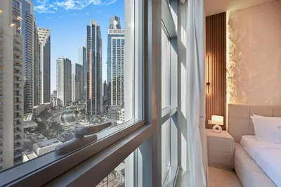 a bedroom with a view of the city from a window at Luxury 2BR Downtown Walk to Dubai Mall Burj Khalifa in Dubai