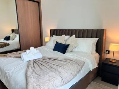 a bedroom with a large bed with towels on it at Modern & Cozy 1BR Apartment with Full Comfort in Dubai