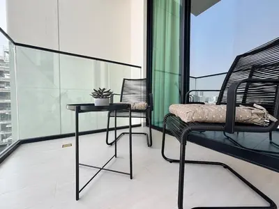 a balcony with a table and chairs on a building at Modern & Cozy 1BR Apartment with Full Comfort in Dubai
