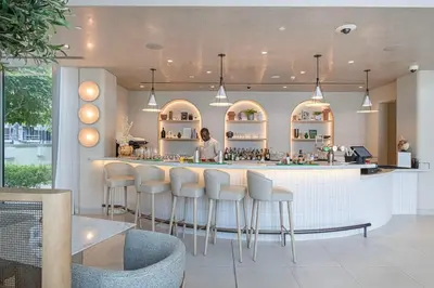 a woman standing at a bar in a restaurant at 4BR Luxury Hotel Amenities Dubai Mall Access in Dubai