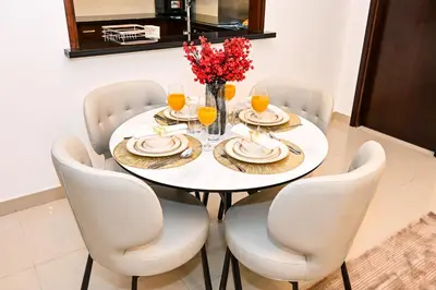 a dining room table with white chairs and a white table at 22nd Floor Burj Khalifa View 5 Min Walk Dubai Mall in Dubai