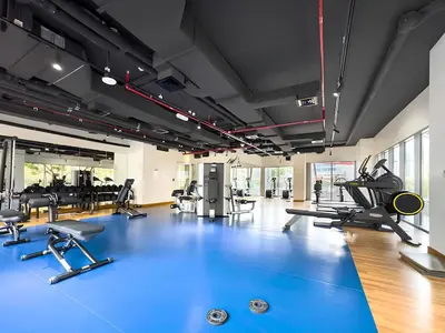 a gym with treadmills and exercise equipment on a blue floor at Luxury 1BHK Burj Khalifa View Short Walk Dubai Mall in Dubai