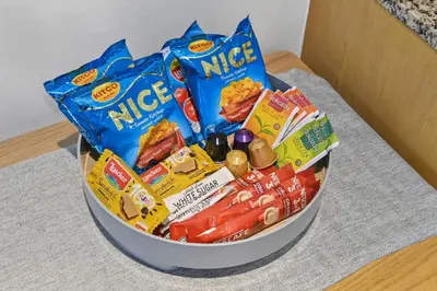 a bucket full of candy and snacks on a table at Luxury 1BHK Burj Khalifa View Short Walk Dubai Mall in Dubai