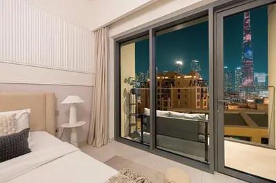 a bedroom with a large window with a view of a city at Designer 2BR, Burj Khalifa View & Dubai Mall 2 minutes walk in Dubai