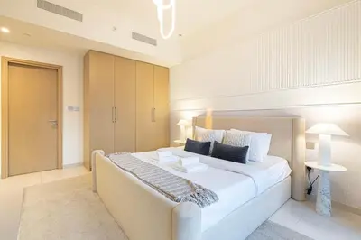 a large bedroom with a large bed with white sheets at Designer 2BR, Burj Khalifa View & Dubai Mall 2 minutes walk in Dubai