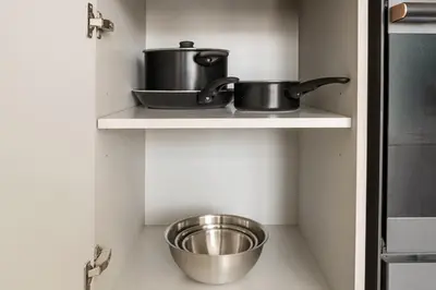 two pots and pans on a shelf in a kitchen at 2.5BR Villa | PS5 & Private Pool | Near Dubai Mall in Dubai